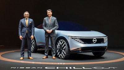 In this photo provided by Nissan Motor Co., Chief Executive Makoto Uchida, right, and COO Ashwani Gupta, left, pose with a Nissan Chill-Out concept car on Nov. 27, 2021.