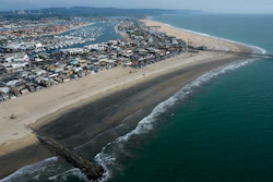 An aerial photo shows the closed beach after oil washed up on a beach in Newport Beach, Calif., on Oct. 6, 2021. A month after an offshore oil spill, environmental advocates say they plan to sue the federal government over the failure to review and update plans for platforms off the Southern California coast.