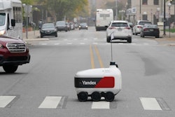 A food delivery robot crosses a street in Ann Arbor, Mich. on Thursday, Oct. 7, 2021. Robot food delivery is no longer the stuff of science fiction. Hundreds of little robots __ knee-high and able to hold around four large pizzas __ are now navigating college campuses and even some city sidewalks in the U.S., the U.K. and elsewhere.
