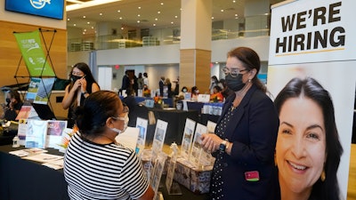 Marriott human resources recruiter Mariela Cuevas, left, talks to Lisbet Oliveros, during a job fair at Hard Rock Stadium, Friday, Sept. 3, 2021, in Miami Gardens, Fla. The number of Americans applying for unemployment benefits fell to a new pandemic low 267,000 last week.