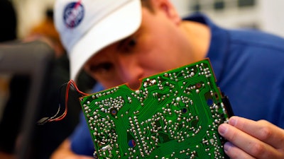 A volunteer repairs a circuit board at a fortnightly repair café event in Malmo, southern Sweden, Sunday Nov. 14, 2021.