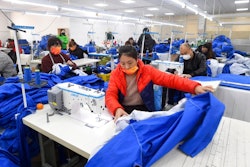 Workers wearing face masks sew fabric in a garment factory in Shenyang in northeastern China's Liaoning Province, Tuesday, Dec. 14, 2021. China reported Wednesday, Dec. 15, 2021, that its economy slowed in November, buffeted by coronavirus outbreaks, weak demand and supply chain disruptions.
