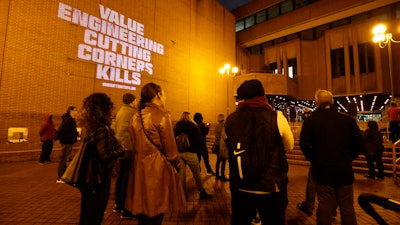 People attend a rally outside Kensington Town Hall to bring attention to the lack of support and action over the Grenfell Tower fire, in London, Sunday Nov. 14, 2021. In 2017 a small kitchen fire in the west London public-housing block turned into the worst domestic blaze in the country since World War II.