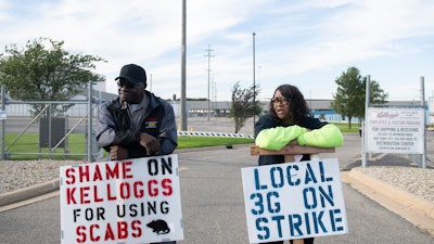 Larry Gamble, who has worked at the Kellogg plant for 13 years, and Sharnita Childress, who has worked at the plant for 8 years, picket with other union workers outside of the plant in Battle Creek, Mich. on Oct. 19, 2021.