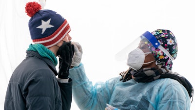 A man is swabbed for COVID-19 at a walk-up testing site at Farragut Square on Dec. 23, 2021, just blocks from the White House in Washington. The explosive increase in U.S. coronavirus case counts is raising alarm, but some experts believe the focus should instead be on COVID-19 hospital admissions. And those aren't climbing as fast.