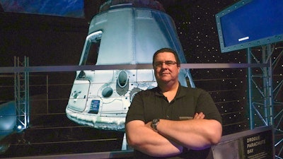 Kyle Hippchen poses in front of a SpaceX Dragon capsule at the Kennedy Space Center Visitor Complex, Cape Canaveral, Fla., Jan. 21, 2022.