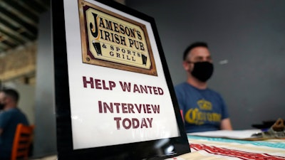 A hiring sign is shown at a booth for Jameson's Irish Pub during a job fair on Sept. 22, 2021, in the West Hollywood section of Los Angeles.