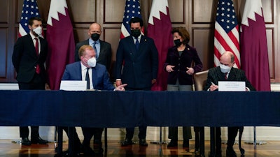 Stan Deal, President and CEO Boeing Commercial Airplanes, left, and Qatar Airways' CEO Akbar al-Baker, right, sign an agreement for the purchase of thirty-four 777-8 Freighter planes with purchase rights for an additional sixteen, in the Eisenhower Executive Office Building on the White House Campus in Washington, Monday, Jan. 31, 2022.