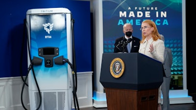 President Joe Biden listens as Jane Hunter, CEO of Tritium, speaks about electric vehicle chargers during an event in the South Court Auditorium in the Eisenhower Executive Office Building on the White House complex, Tuesday, Feb. 8, 2022, in Washington.