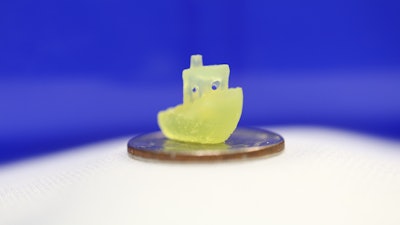 A boat figurine produced by a new 3D printing process that makes it possible to print an object within a volume of resin –like an action figure floating in the center of a block of Jell-O–rather than having to build the object layer by layer.