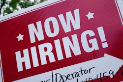 A 'now hiring' sign is posted in Garnet Valley, Pa., Monday, May 10, 2021. Applications for unemployment benefits inched down last week, Thursday, April 21, 2022, as the total number of Americans collecting aid fell to its lowest level in more than 50 years.