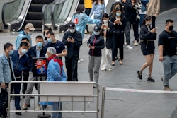 People line up for COVID-19 tests at a testing site in an office complex in Beijing, Friday, April 29, 2022.
