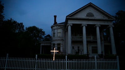 An illuminated cross stands in front of a residence near downtown Dawson, Ga., on April 17, 2020. Both Rocky Ford, Colorado, and Dawson, Georgia, were classified as urban areas after the 2010 census because they had populations over 2,500 residents. Under new criteria posted this spring by the U.S. Census Bureau, these communities would no longer be designated as urban. The new criteria require places to have 2,000 housing units, which is equivalent to 5,000 residents, to be considered an urban area.