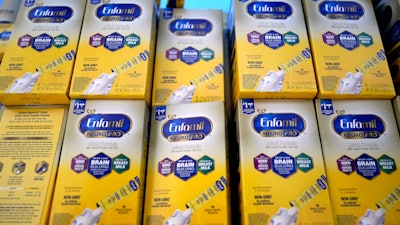 Infant formula is stacked on a table during a baby formula drive to help with the shortage May 14, 2022, in Houston. President Joe Biden has invoked the Defense Production Act to speed production of infant formula and has authorized flights to import supply from overseas.