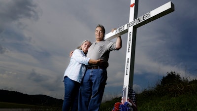 In this Aug. 6, 2019, photo, Ansol and Janie Clark pose at a memorial Ansol Clark constructed near the Kingston Fossil Plant in Kingston, Tenn. The Tennessee Valley Authority was responsible for a massive coal ash spill at the plant in 2008 that covered a community and fouled rivers. The couple says the memorial is for the workers who have come down with illnesses, some fatal, including cancers of the lung, brain, blood and skin and chronic obstructive pulmonary disease. Ansol Clark who drove a fuel truck for four years at the cleanup site, and suffered from a rare blood cancer, has also died now.