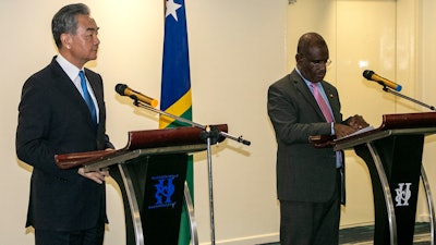 China Foreign Minister Wang Yi, left, and his counterpart from the Solomon Islands, Jeremiah Manele, hold a joint news conference in Honiara, Solomon Islands, May 26, 2022.