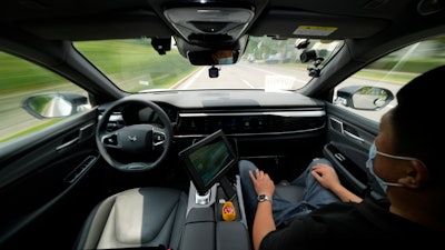 A technician monitors the self-driving taxi developed by tech giant Baidu Inc. on June 14, 2022, in Beijing. Baidu Inc. is China's highest-profile competitor in a multibillion-dollar race with Alphabet Inc.'s Waymo and General Motors Co.'s Cruise to create self-driving cars.