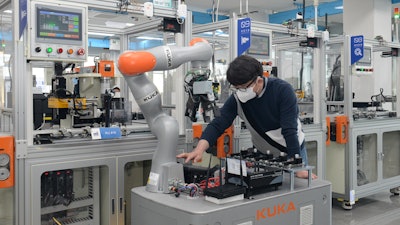 A researcher of the ETRI is controlling a mobile robot by using 5G technology in smart factory.