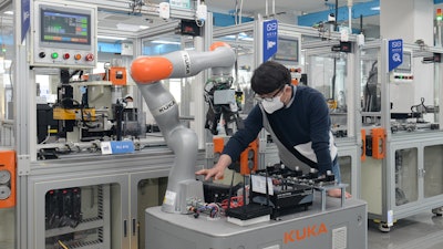 A researcher of the ETRI is controlling a mobile robot by using 5G technology in smart factory.