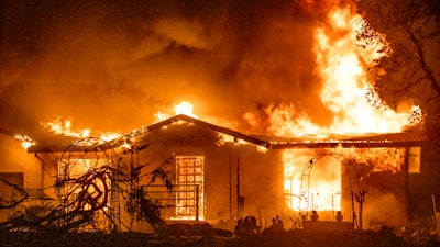 In this Sept. 27, 2020, file photo, a house burns on Platina Road at the Zogg Fire near Ono, Calif. Pacific Gas & Electric on Thursday, June 9, 2022, pleaded not guilty to involuntary manslaughter and other charges it faces after its equipment sparked a Northern California wildfire in 2020 that killed four people and destroyed hundreds of homes.