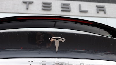In this April 26, 2020 photo, the company logo shines off the rear deck of an unsold 2020 Model X at a Tesla dealership in Littleton, Colo. Tesla’s sales from April through June 2022 fell to their lowest quarterly level since last fall as supply chain issues and pandemic restrictions in China hobbled production of its electric vehicles.