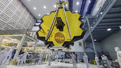 In this April 13, 2017, photo provided by NASA, technicians lift the mirror of the James Webb Space Telescope using a crane at the Goddard Space Flight Center in Greenbelt, Md.