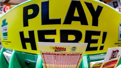 A Mega Millions playslip for those players preferring to choose the numbers they want to play is among the stacks of other lottery game playslips displayed at a Smoker Friendly store in Cranberry Township, Pa., Friday, Jan. 22, 2021.