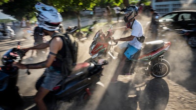 People gather on their electric scooters to spend the late afternoon showing off stunts and racing in Havana, Cuba, Friday, July 15, 2022.