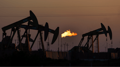 A flare burns off methane and other hydrocarbons as oil pumpjacks operate in the Permian Basin in Midland, Texas, Tuesday, Oct. 12, 2021. Massive amounts of methane are venting into the atmosphere from oil and gas operations across the Permian Basin, new aerial surveys show. The emission endanger U.S. targets for curbing climate change.