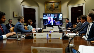 President Joe Biden, on screen at center, participates in a meeting with SK Group Chairman Chey Tae-won, fourth from right, from the Roosevelt Room of the White House in Washington, Tuesday, July 26, 2022. The meeting comes as the Biden administration is seeking the cooperation of Asian allies such as South Korea to reinforce supply chains for critical components such as semiconductors.