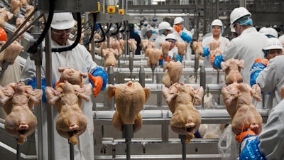 Workers process chickens at a poultry plant in Fremont, Neb., Dec. 12, 2019. The federal government on Monday, Aug. 1, 2022, announced proposed new regulations that would force food processors to reduce the amount of salmonella bacteria found in some raw chicken products or risk being shut down.