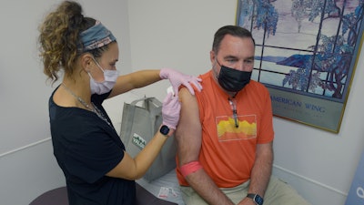 Robert Terwilliger, right, of Williamsburg, Pa., who is participating in a Lyme disease vaccine trial at the Altoona Center for Clinical Research, is injected with either the new vaccine or a placebo, by registered nurse Janae Roland, Friday, Aug. 5, 2022, in Duncansville, Pa. Lyme is a growing problem, with cases steadily rising and warming weather helping ticks expand their habitat.