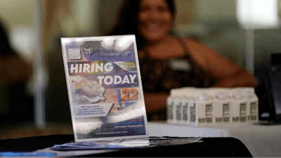 A hiring sign is placed at a booth for prospective employers during a job fair Wednesday, Sept. 22, 2021, in the West Hollywood section of Los Angeles.