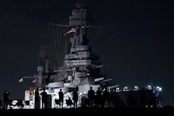 People watch as the USS Texas is moved from the dock Wednesday, Aug. 31, 2022, in La Porte, Texas. The vessel, which was commissioned in 1914 and served in both World War I and World War II, is being towed down the Houston Ship Channel to a dry dock in Galveston where it will undergo an extensive $35 million repair.