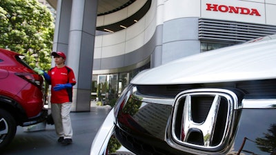 An employee of Honda Motor Co. cleans a Honda car displayed at its headquarters in Tokyo on July 31, 2018. Honda’s fiscal first quarter profit fell 33% from 2021 as a global computer chip shortage, a pandemic-related lockdown in China and the rising costs of raw materials hurt the Japanese automaker. Tokyo-based Honda Motor Co. reported Wednesday, Aug. 10, 2022, that its profit totaled 149.2 billion yen ($1.1 billion) in the April-June quarter, down from 222.5 billion yen ($1.7 billion) a year earlier. Quarterly sales slipped 7% to 3.8 trillion yen ($28 billion).