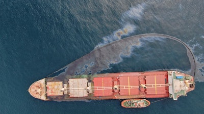 In this photo provided by the Gibraltar government and taken on Thursday Sept. 1, 2022, a leak of heavy fuel oil, a small amount of which has escaped the perimeter of the boom sits on the surface of the sea by the Tuvalu-registered OS 35 cargo ship that collided with a liquid natural gas carrier in the bay of Gibraltar on Tuesday.