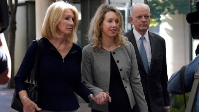 Former Theranos CEO Elizabeth Holmes, middle, and her mother, Noel Holmes, left, arrive at federal court in San Jose, Calif., Thursday, Sept. 1, 2022.