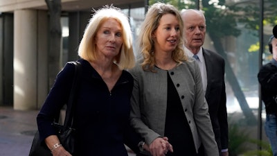 Former Theranos CEO Elizabeth Holmes, center, her mother, Noel Holmes, left, and father, Christian Holmes IV, arrive at federal court in San Jose, Calif., Thursday, Sept. 1, 2022.