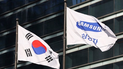 The company flag of Samsung Electronics, right, flutters next to the South Korean national flag in Seoul, South Korea, on Jan. 16, 2017.