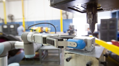 OnRobot's RG6 gripper tending a pin stamper.