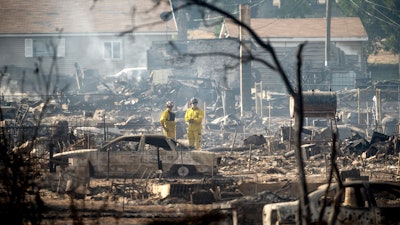 Firefighters survey homes on Wakefield Avenue destroyed by the Mill Fire on Saturday, Sept. 3, 2022, in Weed, Calif.