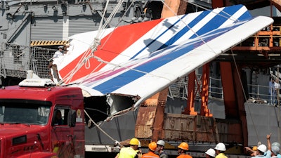 Workers unload debris, belonging to the crashed Air France flight AF447, from the Brazilian Navy's Constitution Frigate in the port of Recife, northeast of Brazil, June 14, 2009.