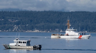 A U.S. Coast Guard boat and Kitsap, Wash., County Sheriff's Office boat search the area near Freeland, Wash., on Whidbey Island north of Seattle, Monday, Sept. 5, 2022, where a chartered floatplane crashed the day before, killing 10 people.