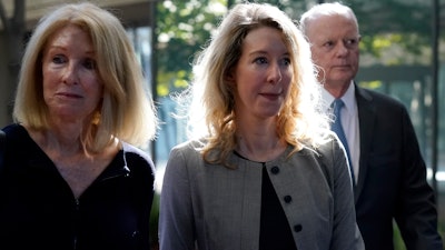 Former Theranos CEO Elizabeth Holmes, center, her mother, Noel Holmes, left, and father, Christian Holmes IV, arrive at federal court in San Jose, Calif., on Sept. 1, 2022.