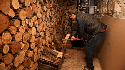 Tudor Popescu chops fire wood he uses for heating in a storage room attached to his home in Chisinau, Moldova, Saturday, Oct. 15, 2022.