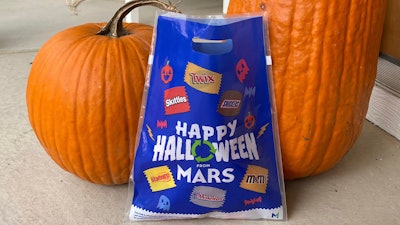 A bag distributed by Mars - the maker of Snickers and M&M's - for recycling candy wrappers is positioned between pumpkins in Ann Arbor, Mich., on October 19, 2022.