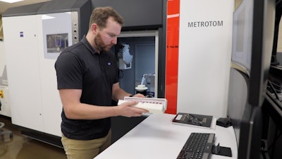 Paul Brackman loads 3D-printed metal samples into a tower for examination using an X-ray CT scan in DOE’s Manufacturing Demonstration Facility at ORNL.