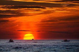 Lobster fishermen work at sunrise in the Atlantic Ocean, Sept. 8, 2022, off of Kennebunkport, Maine.