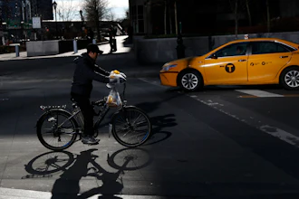 A man making deliveries rides an electronic bike in New York, Dec. 21, 2017.