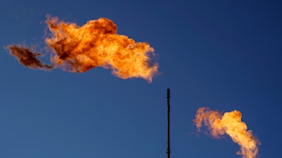 Flares burn off methane and other hydrocarbons at an oil and gas facility in Lenorah, Texas, Oct. 15, 2021.